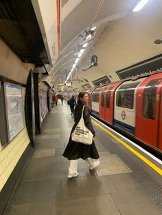 a woman is waiting for the subway to arrive