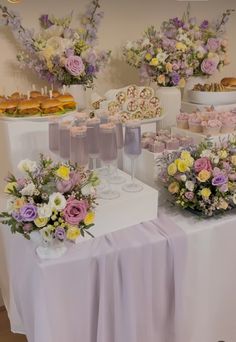 the table is covered with flowers and desserts