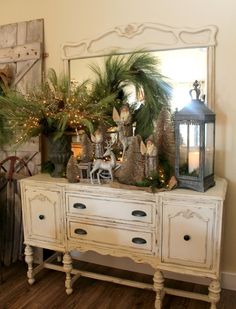 a white dresser topped with lots of christmas decorations