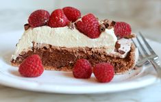 a piece of cake on a plate with raspberries