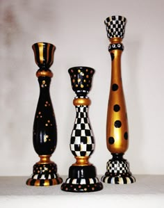 three black and gold vases sitting next to each other