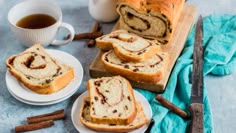 slices of cinnamon swirl bread on plates next to a cup of coffee and cinnamon sticks