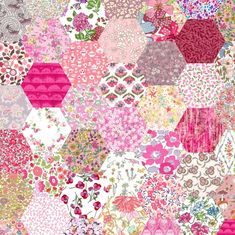 a large patchwork quilt with lots of different colors and patterns on the fabric, including pink