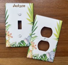 two light switch covers with animals and palm leaves on them, one has a name plate