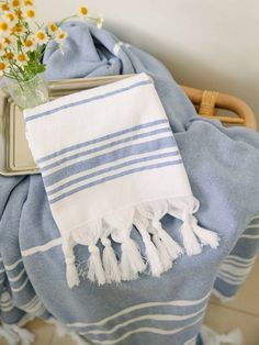 a blue and white towel sitting on top of a table next to a vase with flowers