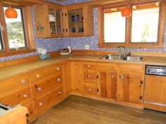 a kitchen with wooden cabinets and wood floors