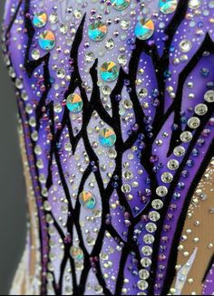 the back of a purple and black dress with lots of sequins on it