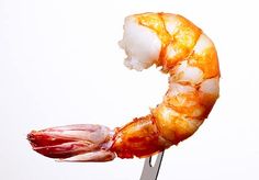 there is a piece of shrimp on a fork in the shape of a letter g