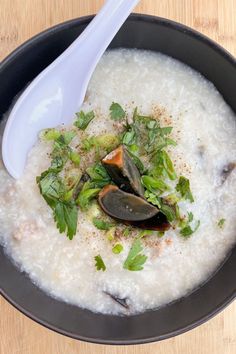 Century Egg Congee with Pork garnished with two small slices of thousand year old egg, cilantro, green onions, and black pepper served in a black bowl with an Asian soup spoon on a wooden surface Vietnamese Porridge, Soup With Pasta, Century Egg, Macaroni Soup, Pork Spare Ribs, Salt Pork, Instant Pot Recipe, Rice Porridge, Vietnamese Cuisine