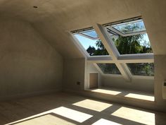 an empty room with two skylights in it