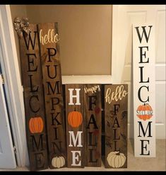 three wooden signs that say welcome and pumpkins