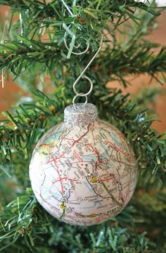 a christmas ornament hanging from the top of a tree with a map on it