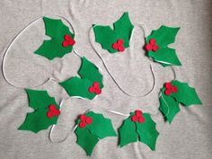 felt christmas holly decorations on a gray background