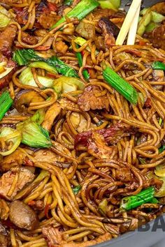 stir fried noodles with meat and vegetables in a wok