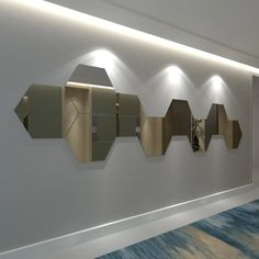 a wall with several mirrors mounted to it's sides and lights on each side