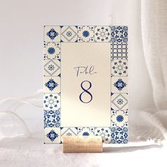 a blue and white place card holder with the number eight printed on it's front