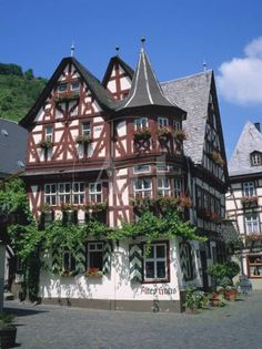 the building has many windows and flowers on it's roof, along with other buildings