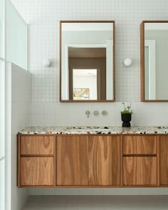 a bathroom with two sinks and mirrors in it