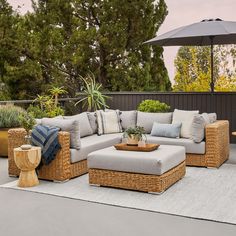 an outdoor living area with wicker furniture and plants on the patio, surrounded by potted trees