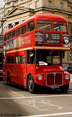 two red double decker buses driving down the street