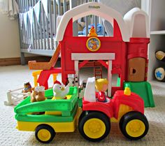 there is a toy truck with animals in it on the floor next to a crib