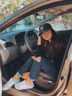 a woman sitting in the driver's seat of a car