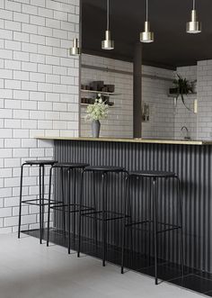 three stools in front of a bar with a mirror on the wall behind it