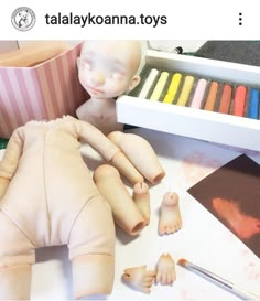 there is a baby doll next to some crayons