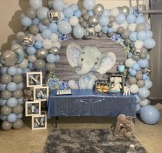 an elephant themed backdrop with balloons and decorations for a baby's first birthday party