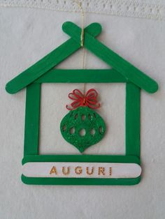 a green house ornament with a red bow