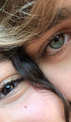 two people with long hair and blue eyes are looking at the same person's eye