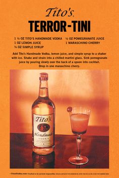 a bottle of liquor sitting next to a glass on top of a wooden table in front of an orange background