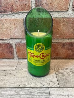 a green candle sitting in front of a brick wall