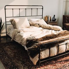 a bed sitting on top of a rug in a bedroom