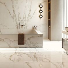 a bathroom with marble walls and flooring next to a bathtub in the middle