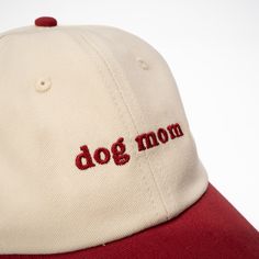 a red and white baseball cap with the word dog mom embroidered on it's peak