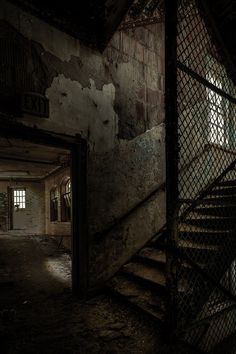 an abandoned building with stairs and windows