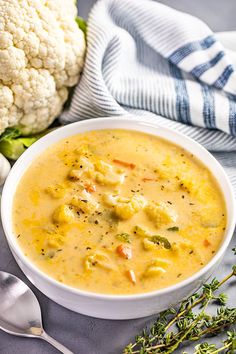 a bowl of soup with cauliflower next to it