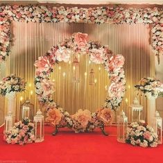 a wedding stage decorated with pink and white flowers, lanterns and candles on the floor