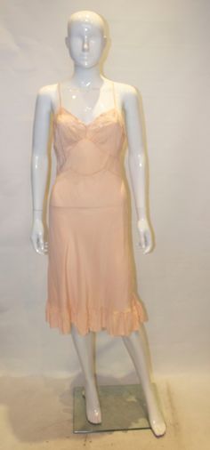 About A vintage silk slip dress in a pretty peach colour.  The slip dress has a v neckline with embroidery on the bust area, and a frill at the hem. Details     Period     1950-1959     Condition     Good     See Condition Descriptions     Bust     36 in. (91.44 cm)     Shoulder to Hem     45 in. (114.3 cm) 1950's Dress, Peach Colour, Vintage 1950s Dresses, 1950s Style, Victoria Dress, Silk Slip Dress, Printed Shirt Dress, Silk Slip, 1950s Fashion