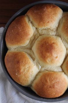 a pan filled with rolls sitting on top of a white cloth