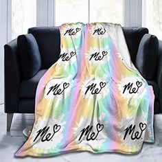 a couch with a blanket on it that says me and no me in cursive writing