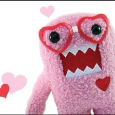 a pink stuffed animal with heart shaped glasses on it's face and mouth is shown