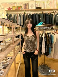 a young woman standing in front of a rack of clothes at a clothing store with her hands on her hips