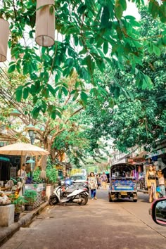 the street is lined with shops and parked motorcycles