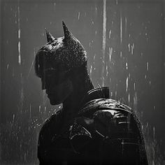 the dark knight rises poster with batman standing in the rain