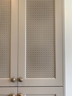 a white cabinet with metal handles and knobs