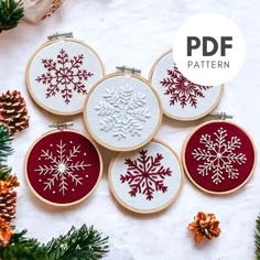 four snowflakes are on the table next to some pine cones and needles