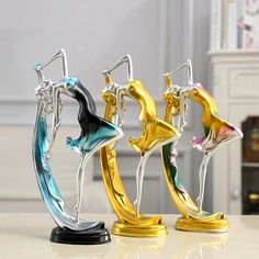 three different colored metal figurines sitting on top of a table