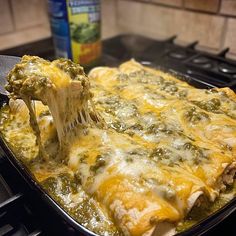 a lasagna casserole being lifted with a spatula from the oven